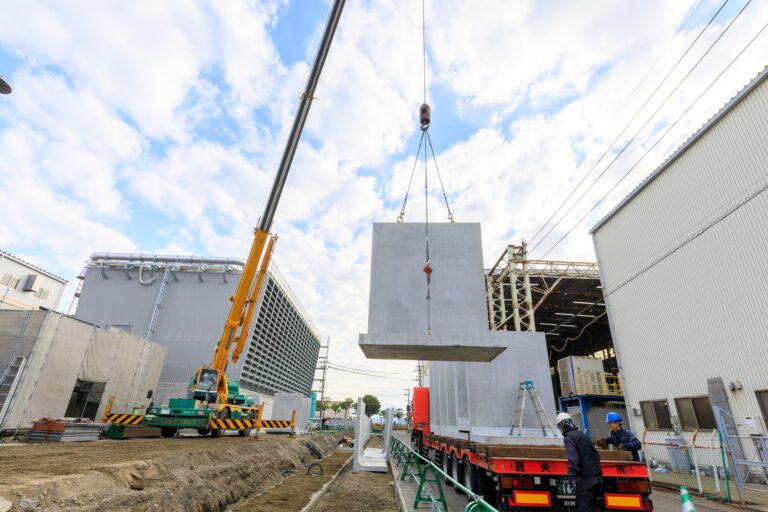大分バイオマスエナジー 発電所（大分市）の塀のねっこ、トレーラーからの荷下ろし